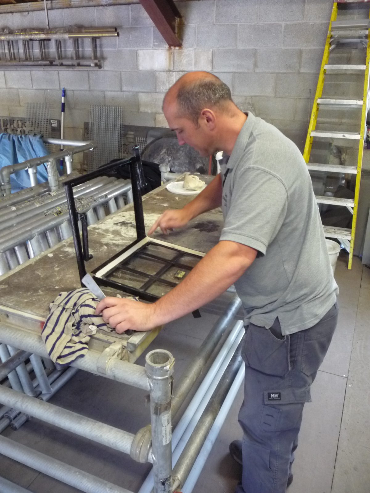 A photograph of window frames from Grade I listed Ford Castle, Berwick-upon-Tweed, Northumberland being glazed in Calibre Metalwork's workshop by their specialist subcontractor, Cheshire Stained Glass.